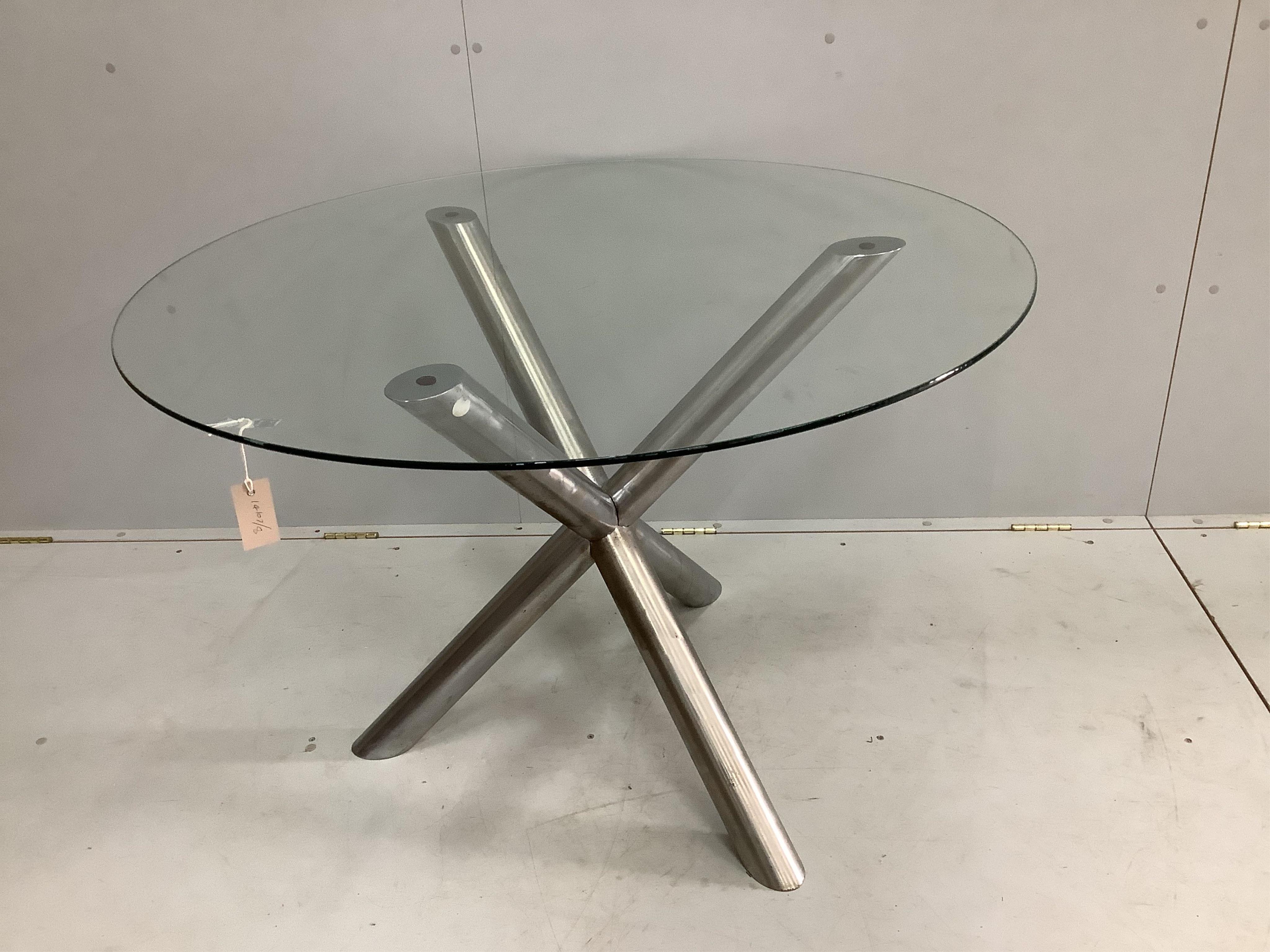 A mid century circular glass topped table on steel X frame support, diameter 110cm, height 74cm